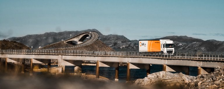 A ColliCare trailer driving through a Norwegian road scenery to deliver predictable goods