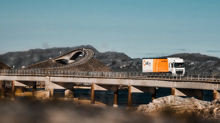 A ColliCare trailer driving through a Norwegian road scenery to deliver predictable goods